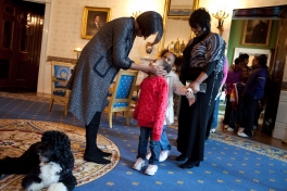 First Lady Michelle Obama greets a young visitor touring the White House during a surprise visit in the Blue Room with family dog Bo on the anniversary of the inauguration, Jan. 20, 2010. (Official White House Photo by Samantha Appleton)
