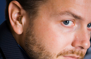 Profile of a man with hearing aid in his ear