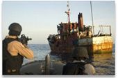 Description: A U.S. Navy boarding team carefully approaches a suspected pirate vessel. Photo courtesy of U.S. Navy