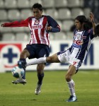 Omar Esparza, izq., pelea el balón contra Damián Álvarez. (AP)