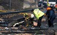 Officials scour debris at the crash site.