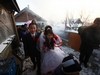 YUSHU, CHINA - DECEMBER 6:  Nineteen-year-old groom Wang Yueming and eighteen-year-old bride Xiao Di walk out of the bridal chamber at the Wangjiacun Village on December 6, 2009 in Yushu of Jilin Province, China. Wang and Xiao are farmers from the village. Usually in the wedding customs of...