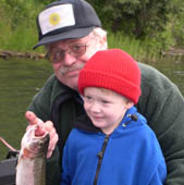 Grandpa and grandson enjoying their big catch, a 17 inch rainbow trout. Alaska. Credit: S. Eckert