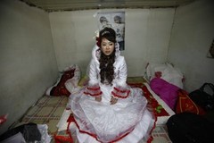 YUSHU, CHINA - DECEMBER 6:  The bride Xiao Di waits for the groom to pick her up at home at the Wangjiacun Village on December 6, 2009 in Yushu of Jilin Province, China. The wedding of Nineteen-year-old Wang Yueming and eighteen-year-old Xiao, who are farmers from the village, were held today...