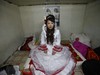 YUSHU, CHINA - DECEMBER 6:  The bride Xiao Di waits for the groom to pick her up at home at the Wangjiacun Village on December 6, 2009 in Yushu of Jilin Province, China. The wedding of Nineteen-year-old Wang Yueming and eighteen-year-old Xiao, who are farmers from the village, were held today...