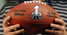 Super Bowl XLV Host Committee chairman Roger Staubach holds a football bearing the official logo for the 2011 NFL championship game.