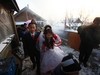 YUSHU, CHINA - DECEMBER 6:  Nineteen-year-old groom Wang Yueming and eighteen-year-old bride Xiao Di walk out of the bridal chamber at the Wangjiacun Village on December 6, 2009 in Yushu of Jilin Province, China. Wang and Xiao are farmers from the village. Usually in the wedding customs of...