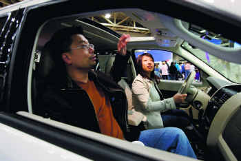 Peter Chao and his wife, Sarah Choi, take a closer look at the 2010 Ford Escape Hybrid at the Dallas Auto Show.