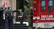 Dallas police officers and Dallas Fire-Rescue personnel confer Monday morning outside the North Dallas office tower where a man shot father-son financial advisers before turning the gun on himself.