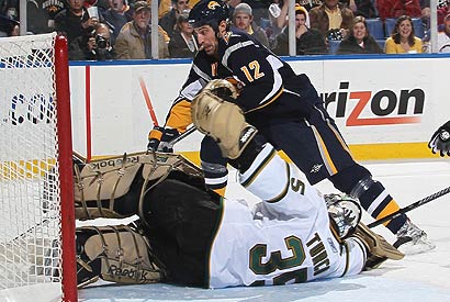 Buffalo's Mark Mancari tries to push the puck past Stars goalie Marty Turco.