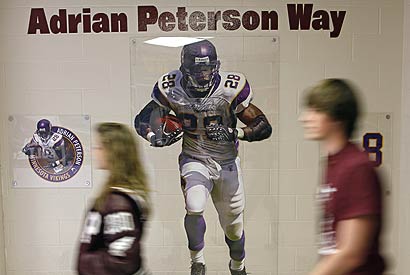 A life-size poster of Minnesota's Adrian Peterson hangs in a  hallway at Palestine High School, where the running back was one of the nation's top prep players.