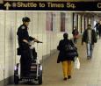 A police officer surveys a crowd moving at New York's Grand Central Subway Station after details emerged that trains might be a target to terrorists.