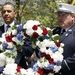 Obama carries a wreath accompanied by a New York ...