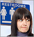 woman standing in front of restroom sign