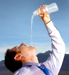 person pouring water into mouth