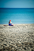 solitary woman sitting on the beach