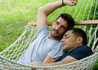 Men relaxing in hammock//"What Makes Love Last?"//© Queerstock/Getty Images 