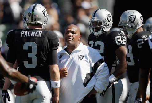 Oakland Raiders head coach Hue Jackson, center, talks with quarterback Carson Palmer before an NFL football game against the Kansas City Chiefs in Oakland, Calif. For nearly a half-century, the Raiders were always Al Davis' team. He picked the players, hired the coaches and devised many of the strategies that led to decades of success, as well as more recent struggles. Davis' death earlier this month created a major void that so far is being filled mostly by coach Jackson. (AP Photo/Paul Sakuma, File)