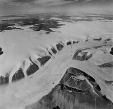 Kalstenius Icefield, located on Ellesmere Island, Canada, shows vast stretches of ice. The icefield produces multiple outlet glaciers that flow into a larger valley glacier.  The glacier in this photograph is three miles wide. (Photo courtesy of the Royal Canadian Air Force, archived at the World Data Center for Glaciology, Boulder, CO.)