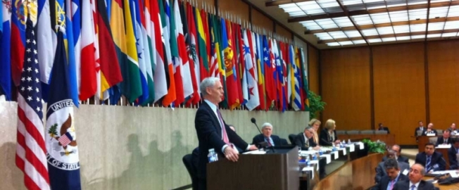 Bryson flanked by flags at the State Department