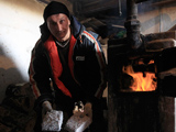 A man feeds briquettes made of worn cash into a furnace in Hungary