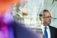 French President Francois Hollande is seen talking with Ministers behind a window glass at the presidential palace
