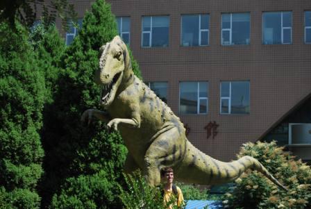 Danny Barta unsuspectingly steps in front of a Monolophosaurus in front of the Institute of Vertebrate Paleontology and Paleoanthropology.