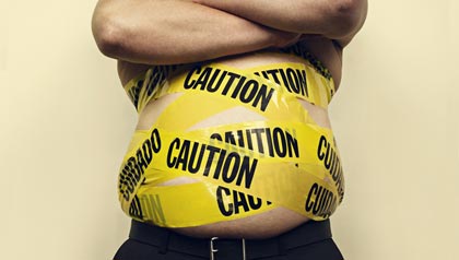 Shirtless man with his waist is wrapped in yellow caution tape