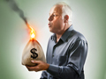 Image of man holding a burning bag of money. What to do with your money when stock market values drop.