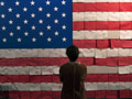 Woman stands in front of an American flag made of petitions