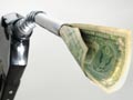 US dollars coming out of a gas pump nozzle-save money on gasoline