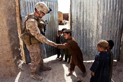 U.S. Marine Corps Cpl. Patrick McCall, left, receives a high five from an Afghan boy during a security patrol in the Sangin district in Afghanistan's Helmand province, Sept. 6, 2012. McCall is a rifleman assigned to Bravo Company, 1st Battalion, 7th Marine Regiment, Regimental Combat Team 6.
