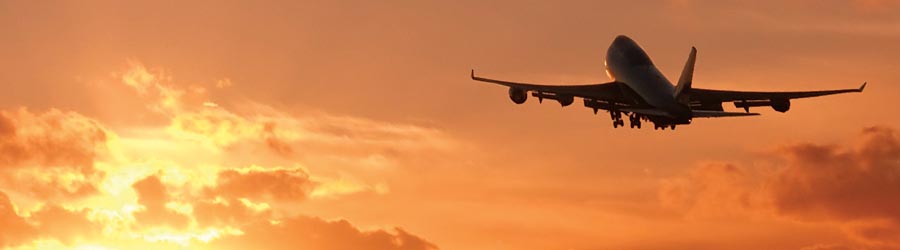 Jet airplane flying toward a sunset