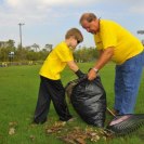 Photo: Madisonville, La., Sep. 8, 2012 -- Norman Ott and his son Weston rack leaves at the local ball park as part of a community clean up operation sponsored by the St. Anselm Catholic Church. Madisonville took on three feet of flood water during Hurricane Isaac.