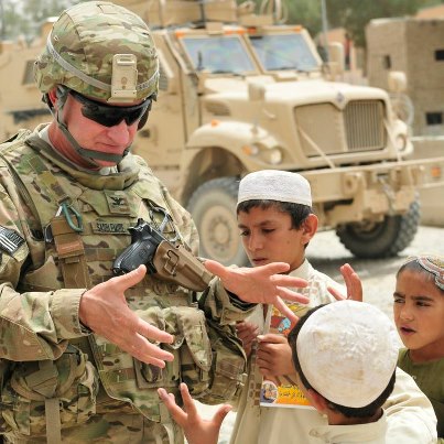 Photo: Col. Alden Saddlemire, 3rd Stryker Brigade Combat Team, 2nd Infantry Division, speaks with local children about obtaining a soccer ball during a visit to the district center in Spin Boldak, Afghanistan, July 23, 2012. Photo by SSG Brendan Mackie