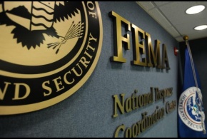 The FEMA logo and DHS Flag on the wall in the National Response and Coordination Center.