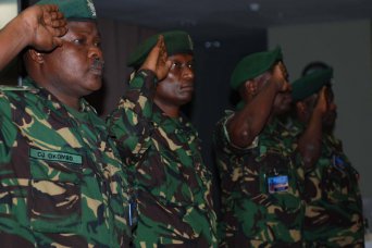 Lt. Col. CJ Okombo, Tanzania People Defence Force, and other TPDF representatives salute during the playing of the national anthems during the opening day of Eastern Accord. Eastern Accord is designed to help U.S. and East African participants improve their capability to respond to regional security threats posed by Violent Extremist Groups and to more effectively counter the associated Violent Extremist Ideology.