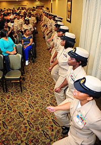 Newly pinned chief petty officers sing Anchors Aweigh during a chief petty officer pinning ceremony for Sailors stationed aboard the aircraft carrier USS George H.W. Bush (CVN 77).