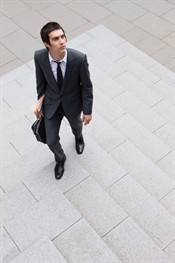 Photo of young man walking up marble steps