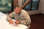 Combat Center Commanding General, Brig. Gen. George W. Smith, is the first to sign his Combined Federal Campaign donation form Sept. 13, 2012, during the base's CFC Kick-Off Breakfast. Smith urged all unit representatives present to take a strongly encouraging approach when talking to their offices about giving.