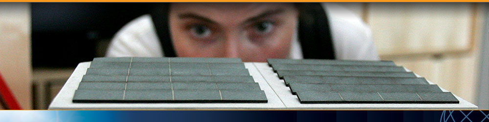 Photo of a woman inspecting a scale model of a solar-powered house.