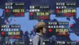 A man walks past a stock quotation board outside a brokerage in Tokyo, Japan, September 14, 2012. 