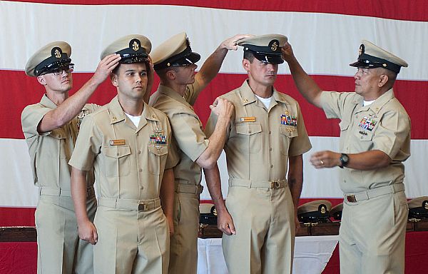 Chief Culinary Specialist Ramon M. Lang and Chief Hospital Corpsman Daniel C. Lang have their chief petty officer combination covers placed during a chief petty officer pinning ceremony. Although stationed far away for much of their careers, the brothers were able to come together with their families for this career milestone.  U.S. Navy Photo by Mass Communication Specialist 2nd Class Oscar Espinoza (Released)  120914-N-CD336-245