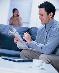 Photo of a man reading a newspaper.