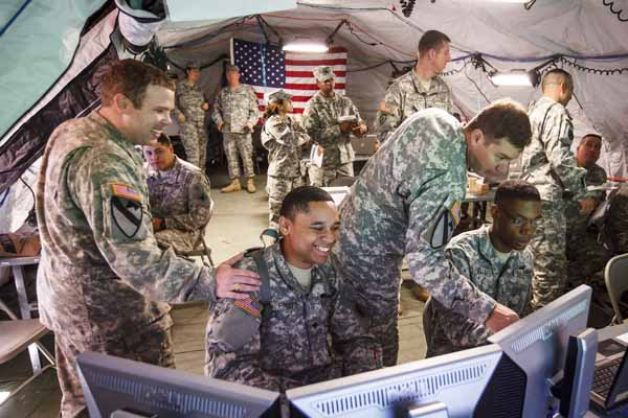 Major Chris Davis (left) pats Spc. Matthew Pruitt on the shoulder as he operates a Command Post of the Future (CPOF) unit during a simulation exercise in a mobile Tactical Operation Center (TOC) for the Fort Hood based 7th Battalion, 158th Aviation Regiment at Ellington Field Joint Reserve Base at Ellington Airport, Monday, April 23, 2012, in Houston. Reserve soldiers with Houston-based 75th Training Division helped conduct high-tech computerized war games for the Fort Hood based 7th Battalion, 158th Aviation Regiment at Ellington Field in Houston to simulate battle for troops headed overseas.
Photo: Michael Paulsen, Houston Chronicle / © 2012 Houston Chronicle 