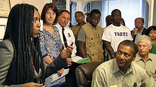 Several people, including Randy and Tom, listen to the Executive Director.