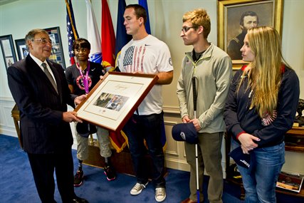 Defense Secretary Leon E. Panetta accepts a gift from U.S. Paralympic Team members Kari Miller, Jeremy Campbell, Brad Snyder and Cortney Jordan during a visit to the Pentagon, Sept. 13, 2012.