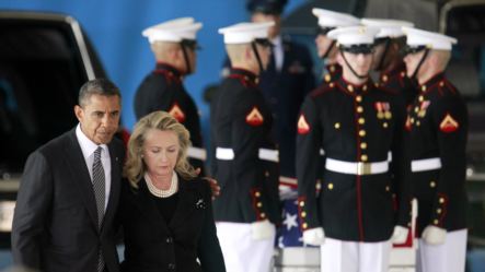 U.S. President Barack Obama walks with Secretary of State Hillary Clinton past the flag-draped transfer case of one of four Americans who died this week in Libya, during a transfer of remains ceremony at Andrews Air Force Base near Washington, September 1