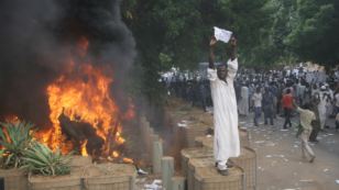 A Sudanese protester stands on a barricade during a demonstration in Khartoum, September 14, 2012, as part of widespread anger across the Muslim world about a film ridiculing Islam's Prophet Muhammad. 