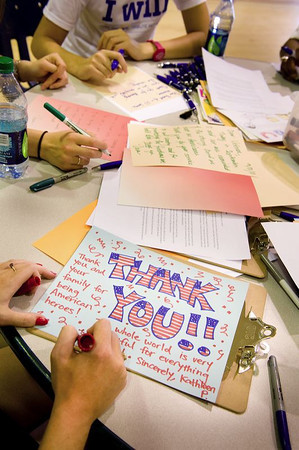 A volunteer writes a thank you letter to the troops at a September 11th National Day of Service and Remembrance event organized by HandsOn Greater DC Cares and U.S. Vets -- United States Veterans Initiative. The event was attended by over 200 White House and Corporation for National and Community Staff and their families. (Corporation photo by Sam Kittner, 2011)